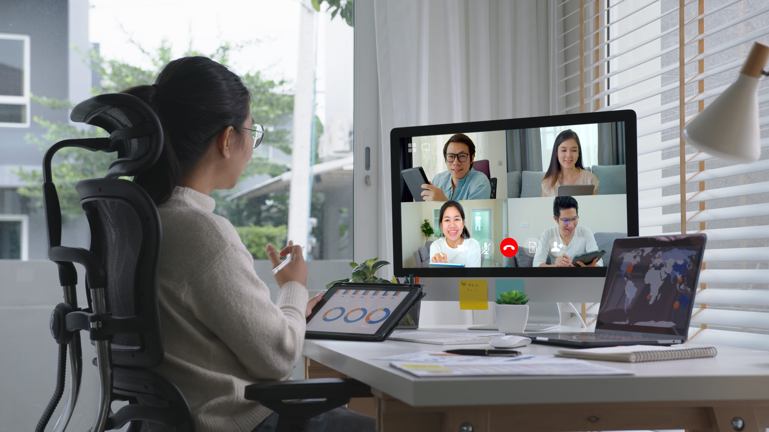 Business woman talking about sale report in video conference.Asian team using laptop and tablet online meeting in video call
